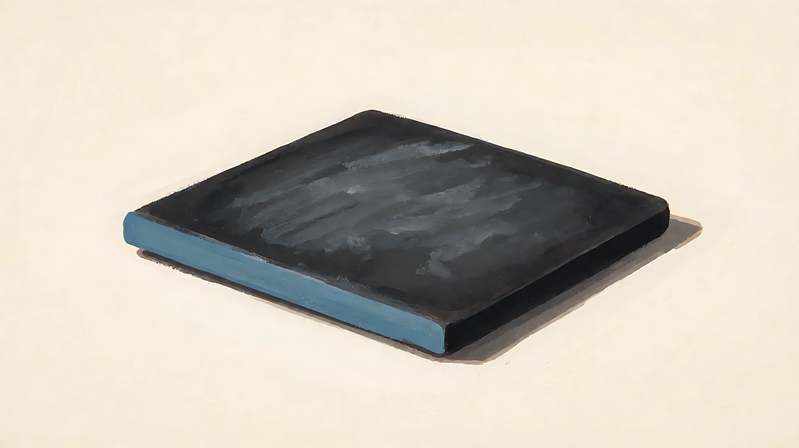A charcoal board lying flat, blank face, one muted blue edge